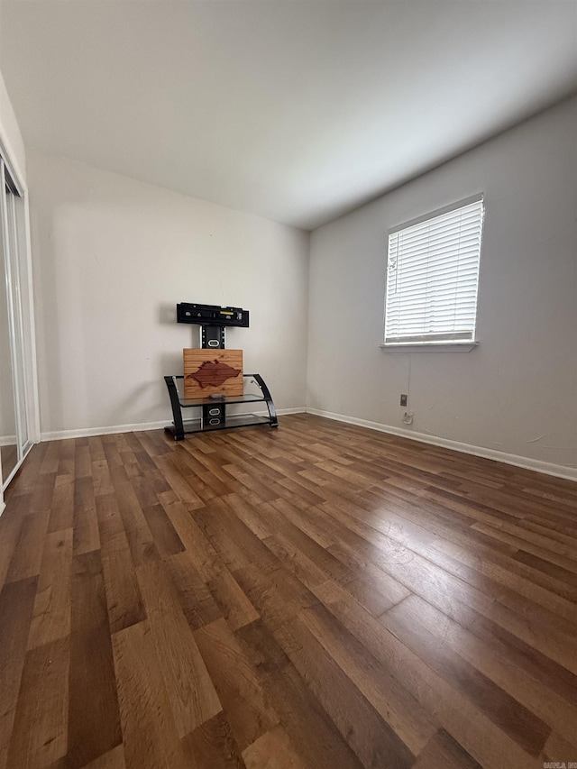 spare room featuring wood finished floors and baseboards