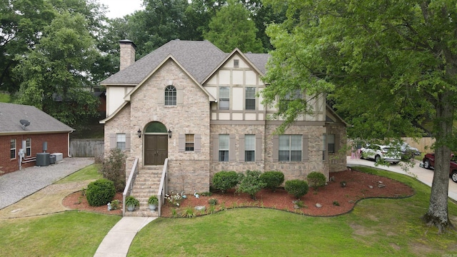 615 Miller Cv, Benton, AR 72019 - view of front of house with a shingled roof, central AC, a chimney, stucco siding, and stone siding