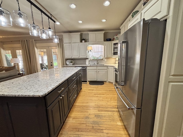 615 Miller Cv, Benton, AR 72019 - kitchen with stainless steel appliances, white cabinetry, light wood finished floors, a center island, and recessed lighting