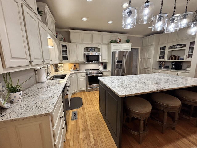 615 Miller Cv, Benton, AR 72019 - kitchen featuring stainless steel appliances, a sink, crown molding, white cabinetry, and light wood finished floors