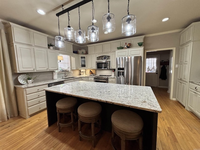 615 Miller Cv, Benton, AR 72019 - kitchen featuring stainless steel appliances, a sink, a center island, light wood finished floors, and white cabinets