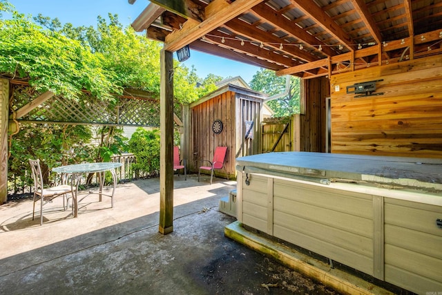 1224 S Fillmore St, Little Rock, AR 72204 - view of patio featuring a hot tub, a storage unit, fence, and an outbuilding