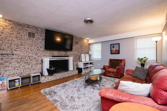 1224 S Fillmore St, Little Rock, AR 72204 - living room with wood finished floors, a textured ceiling, and a fireplace with raised hearth