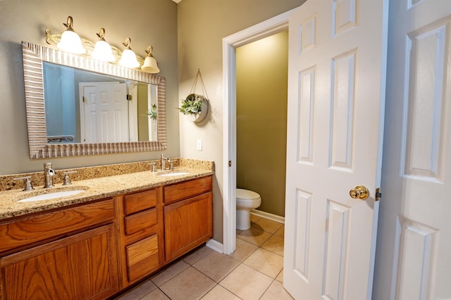 full bath with tile patterned flooring, toilet, double vanity, and baseboards