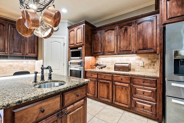 5410 Lexington Ave, Benton, AR 72019 - kitchen featuring appliances with stainless steel finishes, a sink, crown molding, light stone countertops, and decorative backsplash
