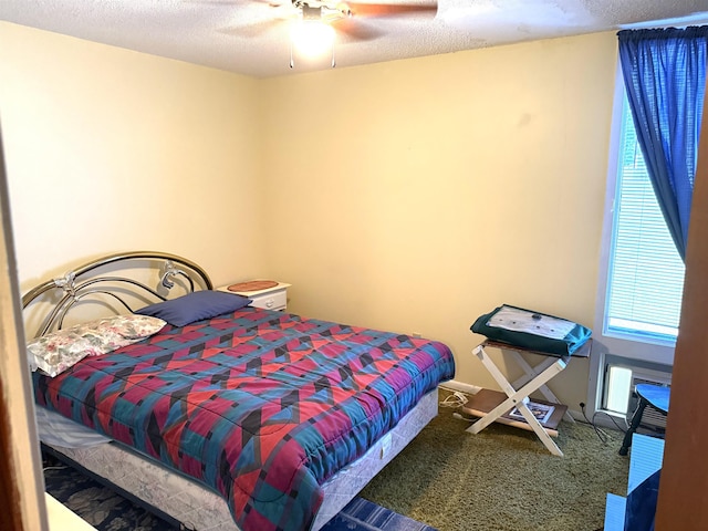 carpeted bedroom featuring a textured ceiling and a ceiling fan