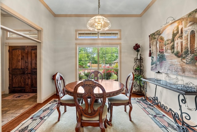 dining space with ornamental molding, a chandelier, wood finished floors, and baseboards