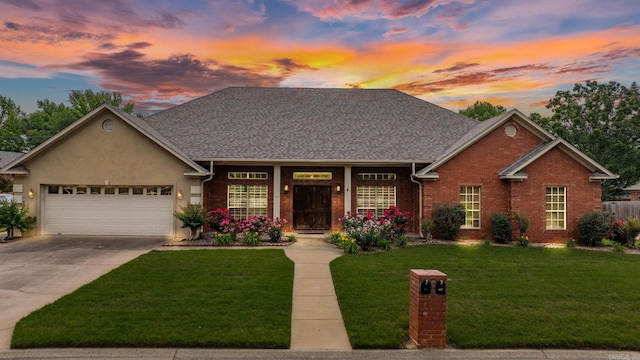 view of front of property featuring a garage, a front yard, driveway, brick siding, and roof with shingles