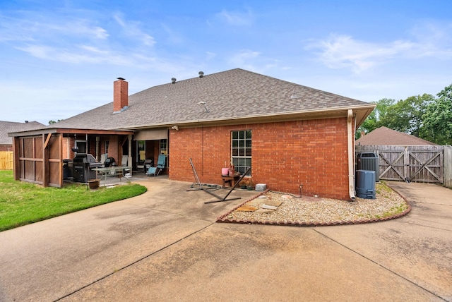 back of property featuring a patio, fence, roof with shingles, a chimney, and a gate