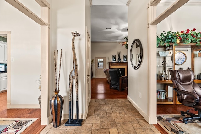 hallway featuring baseboards and stone tile floors
