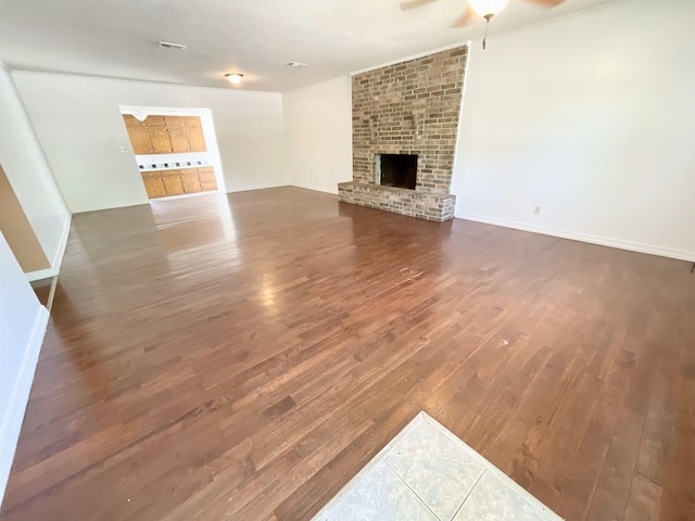 806 Autumnwood Rd, Ash Flat, AR 72513 - unfurnished living room featuring wood finished floors, a ceiling fan, baseboards, and a brick fireplace