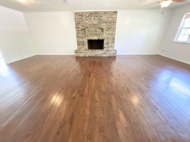 806 Autumnwood Rd, Ash Flat, AR 72513 - unfurnished living room featuring wood finished floors, a ceiling fan, a fireplace, and baseboards