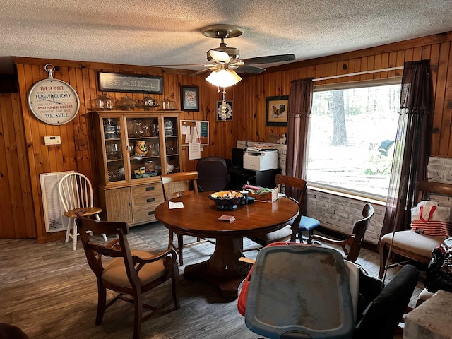 340 Griffin Rd, Hardy, AR 72542 - dining area featuring wood walls, a ceiling fan, a textured ceiling, and wood finished floors