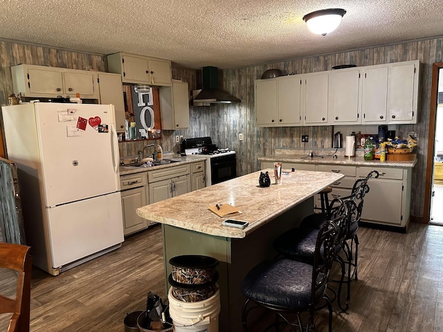 340 Griffin Rd, Hardy, AR 72542 - kitchen with black range with gas cooktop, wall chimney exhaust hood, freestanding refrigerator, light countertops, and dark wood-style flooring