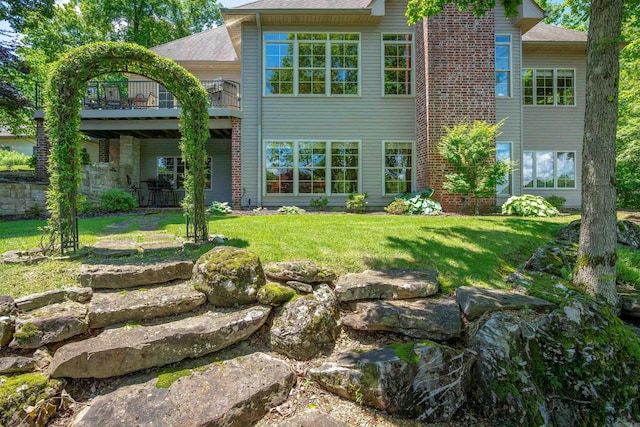 26 Pillar Ln, Hot Springs Village, AR 71909 - back of property with a lawn, a shingled roof, and a balcony