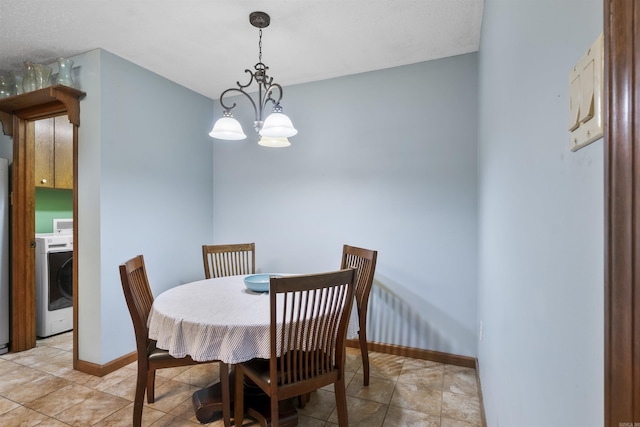 dining room featuring washer / clothes dryer, baseboards, and a chandelier