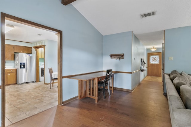 living room with light wood-type flooring, washer / dryer, lofted ceiling, and baseboards