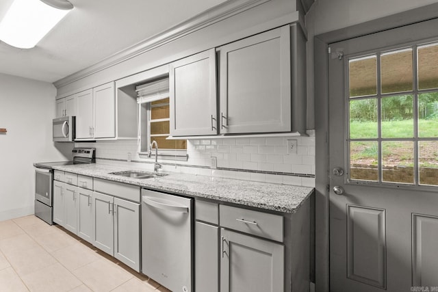 1118 Garland, North Little Rock, AR 72216 - kitchen featuring stainless steel appliances, a sink, decorative backsplash, light tile patterned floors, and light stone countertops