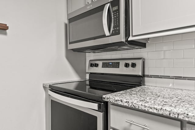 1118 Garland, North Little Rock, AR 72216 - kitchen with appliances with stainless steel finishes, backsplash, and light stone counters