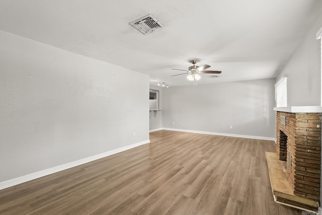 1118 Garland, North Little Rock, AR 72216 - unfurnished living room with a ceiling fan, wood finished floors, baseboards, and a brick fireplace