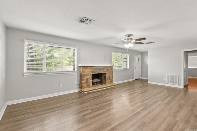 1118 Garland, North Little Rock, AR 72216 - unfurnished living room with a ceiling fan, a fireplace, light wood-type flooring, and baseboards