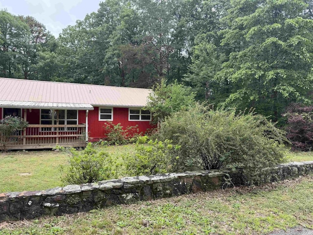 122 Meadow Cliff Cir, Fairfield Bay, AR 72088 - view of front of property with metal roof, a wooden deck, a forest view, and a front lawn