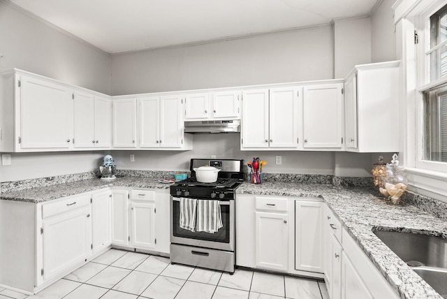 1905 S Battery St, Little Rock, AR 72202 - kitchen with stainless steel gas range, white cabinets, under cabinet range hood, light stone countertops, and a sink