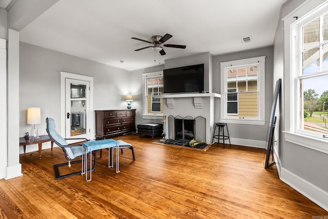 1905 S Battery St, Little Rock, AR 72202 - living area featuring a ceiling fan, a brick fireplace, wood finished floors, and baseboards