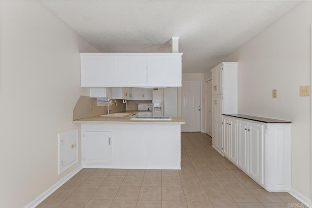 51 Fieldcrest Cir, Cabot, AR 72086 - kitchen with white refrigerator with ice dispenser, a sink, a peninsula, light tile patterned floors, and white cabinetry