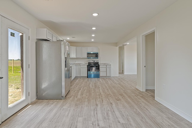 kitchen with appliances with stainless steel finishes, light wood-style floors, recessed lighting, light countertops, and white cabinetry