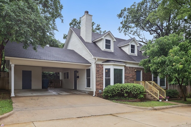 4911 B St, Little Rock, AR 72205 - new england style home featuring concrete driveway, fence, brick siding, a chimney, and a carport