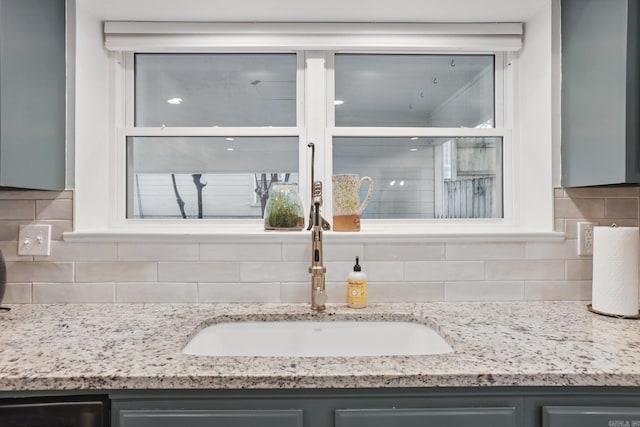 4911 B St, Little Rock, AR 72205 - detailed view of gray cabinets, a sink, and backsplash