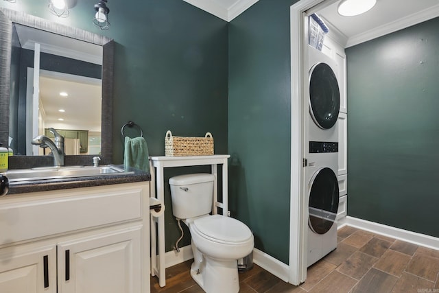 4911 B St, Little Rock, AR 72205 - bathroom with stacked washer / drying machine, crown molding, toilet, wood finish floors, and baseboards