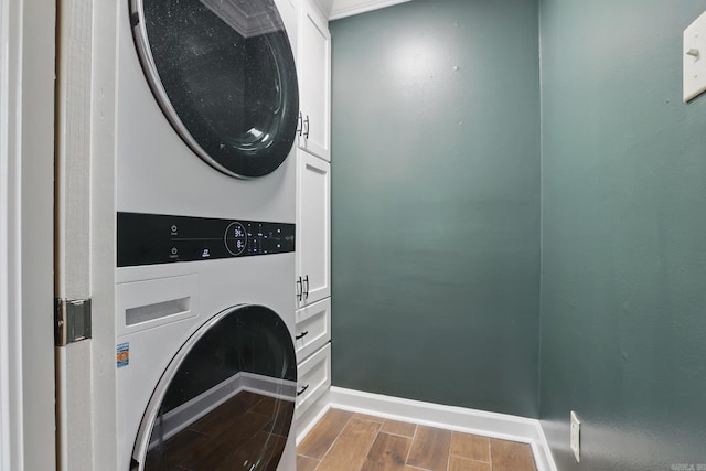 4911 B St, Little Rock, AR 72205 - laundry room with cabinet space, estacked washer and dryer, wood tiled floors, and baseboards