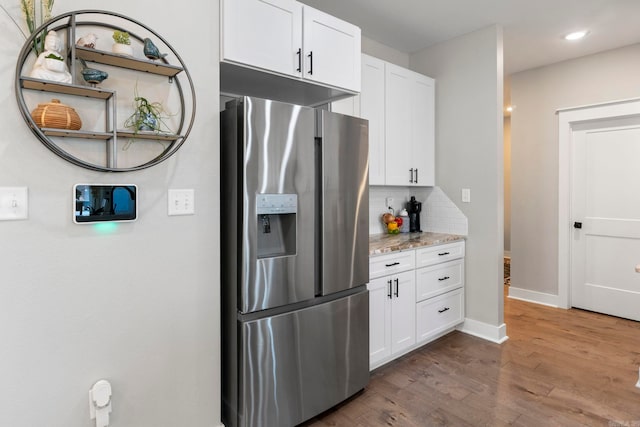 5101 Peace Ln, Alexander, AR 72002 - kitchen featuring stainless steel refrigerator with ice dispenser, tasteful backsplash, wood finished floors, white cabinets, and light stone countertops