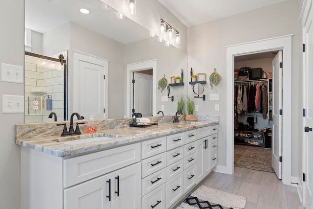 5101 Peace Ln, Alexander, AR 72002 - full bathroom with double vanity, a shower stall, a spacious closet, and baseboards