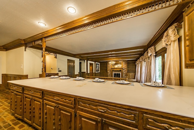 5401 N Hills Blvd, North Little Rock, AR 72116 - kitchen with brick flooring, crown molding, light countertops, a brick fireplace, and recessed lighting