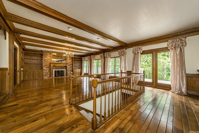 5401 N Hills Blvd, North Little Rock, AR 72116 - unfurnished living room featuring hardwood / wood-style floors, beamed ceiling, a brick fireplace, a chandelier, and built in features