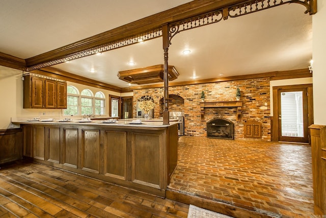 5401 N Hills Blvd, North Little Rock, AR 72116 - kitchen with a peninsula, a fireplace, ornamental molding, light countertops, and wall oven