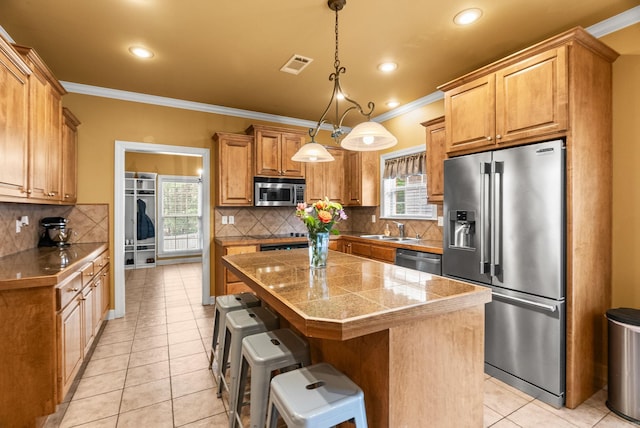 121 Lily Dr, Maumelle, AR 72113 - kitchen featuring appliances with stainless steel finishes, tile countertops, a sink, crown molding, and light tile patterned floors