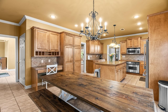 121 Lily Dr, Maumelle, AR 72113 - kitchen with stainless steel appliances, a chandelier, a center island, tasteful backsplash, and crown molding