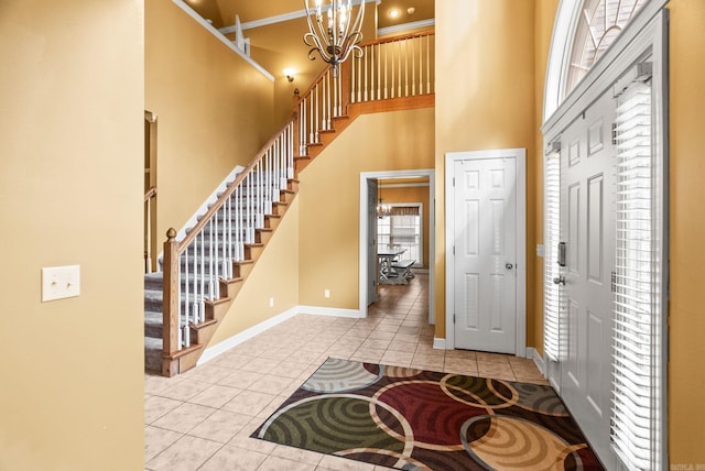 121 Lily Dr, Maumelle, AR 72113 - entrance foyer with tile patterned floors, a high ceiling, a chandelier, baseboards, and stairway