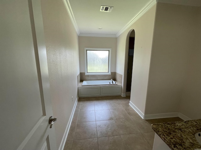 hall with arched walkways, crown molding, light tile patterned flooring, and baseboards