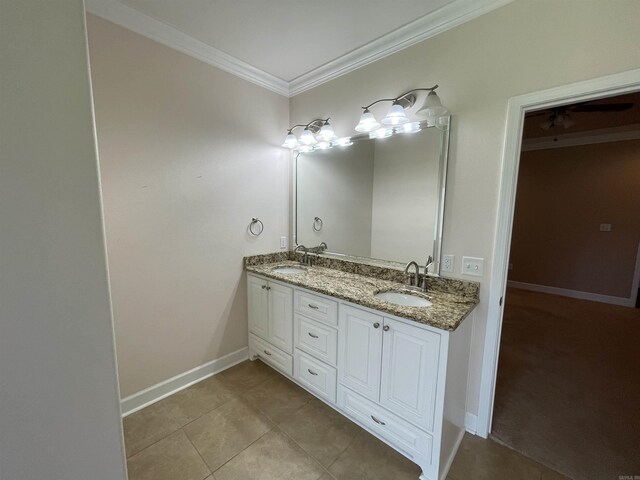 bathroom featuring ornamental molding, baseboards, tile patterned floors, and double vanity