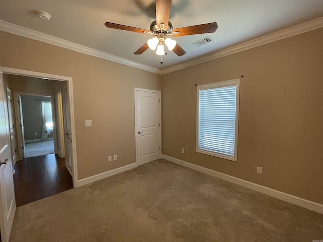 spare room with ornamental molding, carpet floors, a ceiling fan, baseboards, and a smoke detector