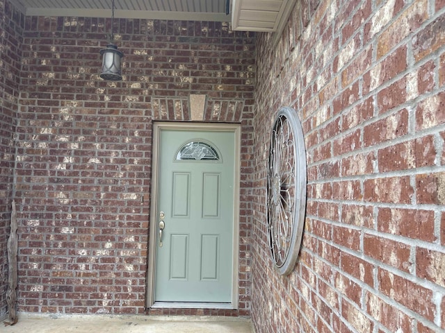 doorway to property with brick siding