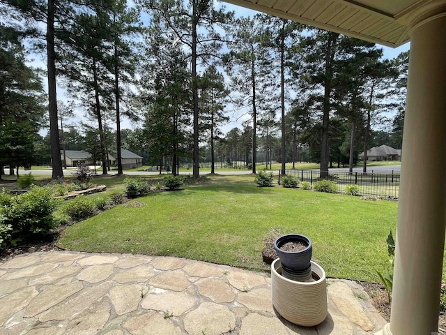 view of yard featuring view of wooded area and a patio area