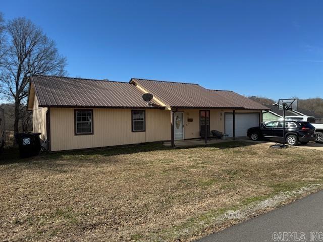 21 Emma Dr, Pocahontas, AR 72455 - view of front of house featuring a garage, metal roof, and a front lawn