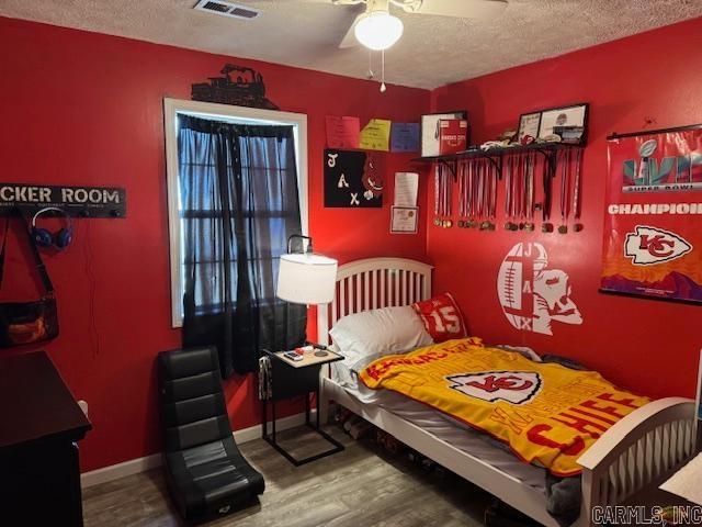 21 Emma Dr, Pocahontas, AR 72455 - bedroom featuring wood finished floors, a textured ceiling, baseboards, and a ceiling fan