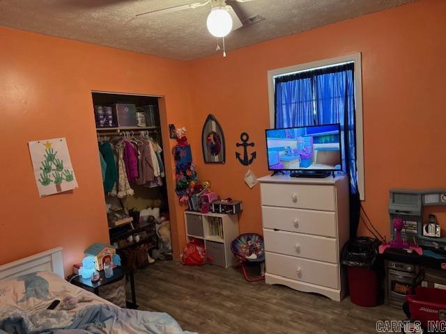 21 Emma Dr, Pocahontas, AR 72455 - bedroom featuring wood finished floors, a closet, a textured ceiling, and a ceiling fan